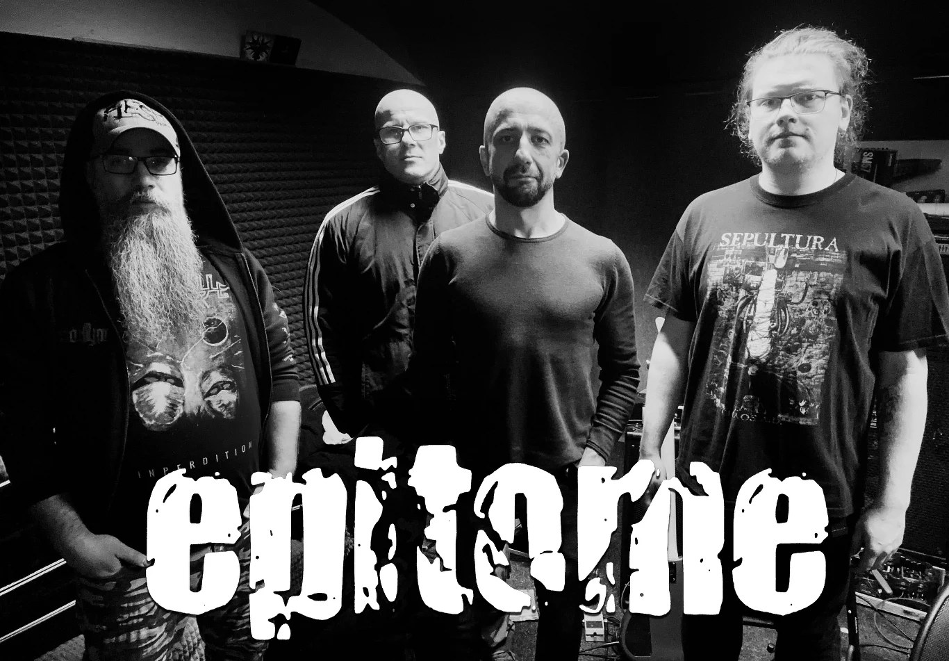 Epitome przed premierą Czterech mężczyzn stoi obok siebie w zaciemnionym pomieszczeniu, z przodu widoczny napis 'epitome'; jeden z mężczyzn nosi koszulkę zespołu Sepultura, inny okulary i ma długą brodę, całość utrzymana w klimacie muzycznym.