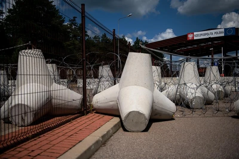 Premier poinformował o zamknięciu granicy Polski z Białorusią Przejście graniczne zabezpieczone betonowymi zaporami, drutem kolczastym oraz ogrodzeniem, w tle widoczny znak graniczny Rzeczypospolitej Polskiej.