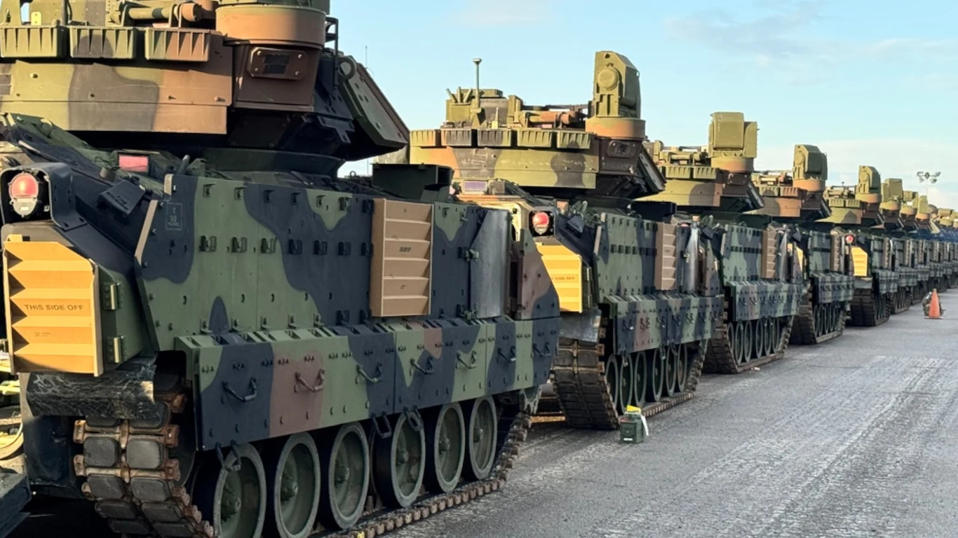 Ponad 100 Bradleyów zmierza do Polski Szereg nowoczesnych pojazdów wojskowych ustawionych w linii na utwardzonym placu; pojazdy mają kamuflaż militarystyczny i wyraźne opancerzenie