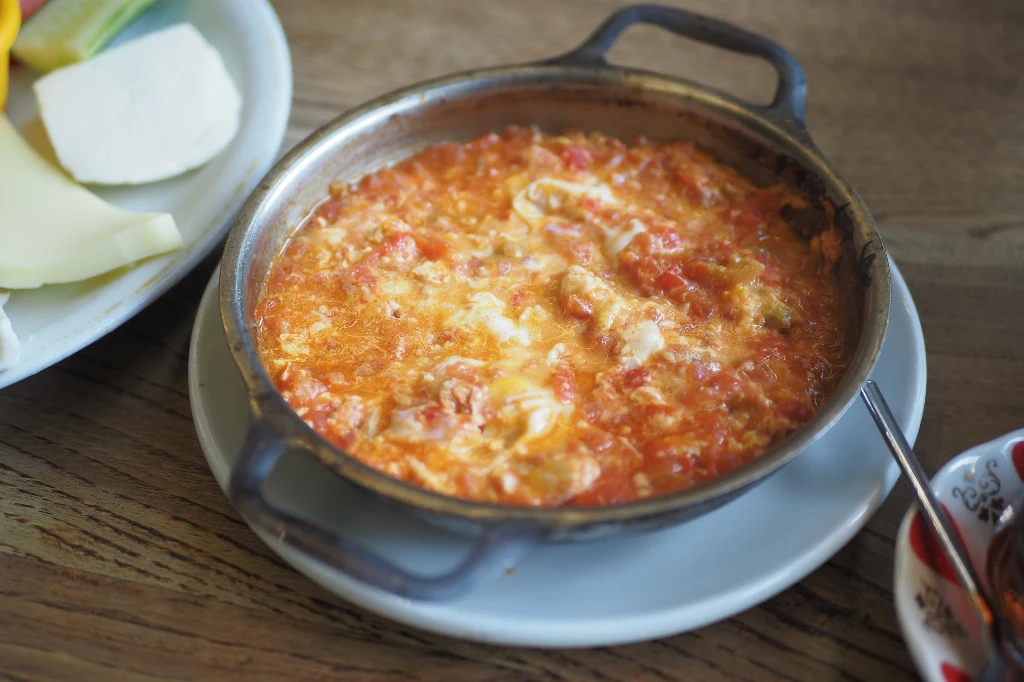 Menemen je się, maczając i nabierając jajecznicę pieczywem Menemen je się, maczając i nabierając jajecznicę pieczywem