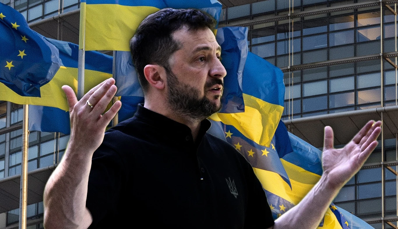 Wołodymyr Zełenski liczy na pozytywną decyzję Rady UE ws. pierwszego klastra. Na drodze stoi polityka Węgier Mężczyzna z zarostem w czarnej koszulce stoi na tle kilku flag Ukrainy oraz Unii Europejskiej, rozpościerając ręce, w tle nowoczesny budynek szklany.