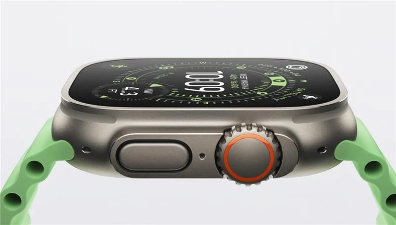 Smartwatch z zielonym paskiem, aluminiową kopertą i okrągłą koronką z pomarańczowym akcentem, wyświetlający szczegółowy cyfrowy interfejs na ekranie dotykowym.