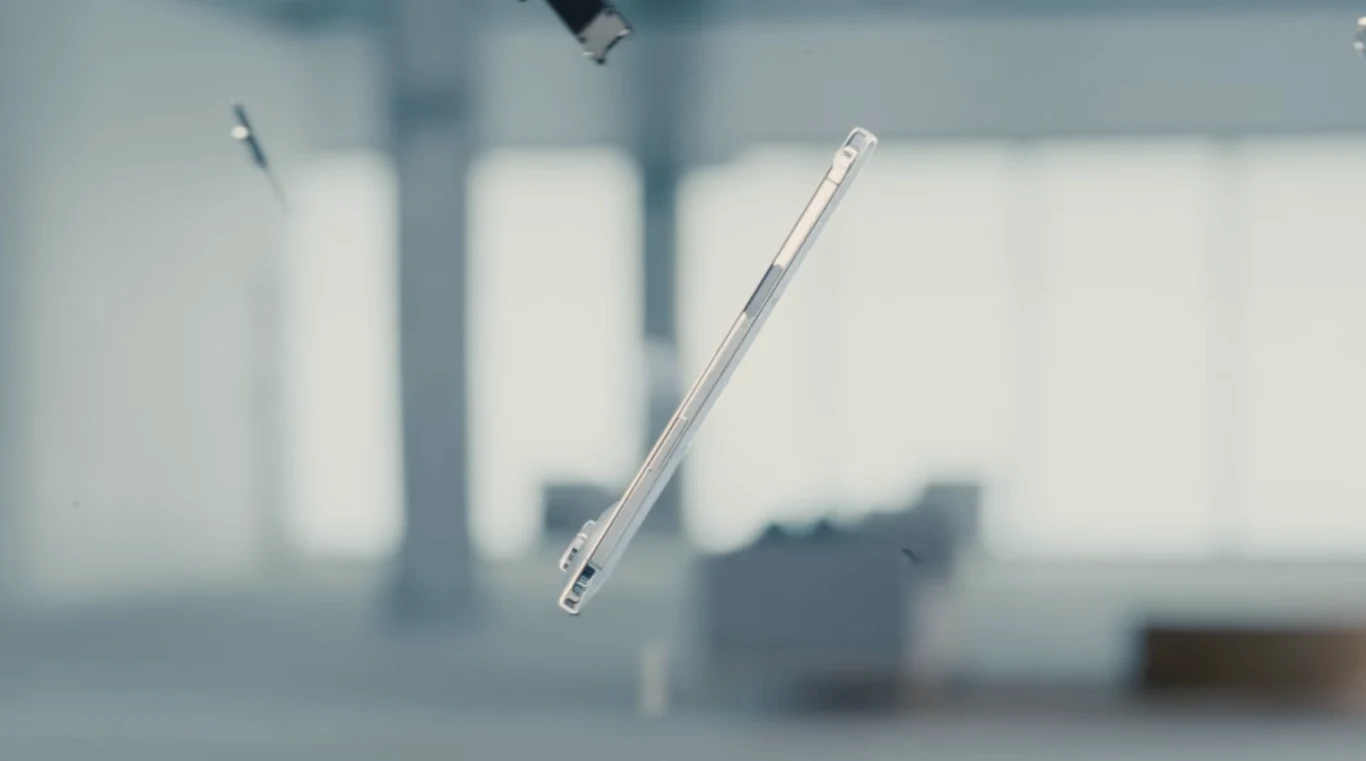 Przezroczyste etui do smartfona unoszące się w powietrzu w jasnym, minimalistycznym wnętrzu, rozmazane elementy tła podkreślają skupienie na obiekcie.