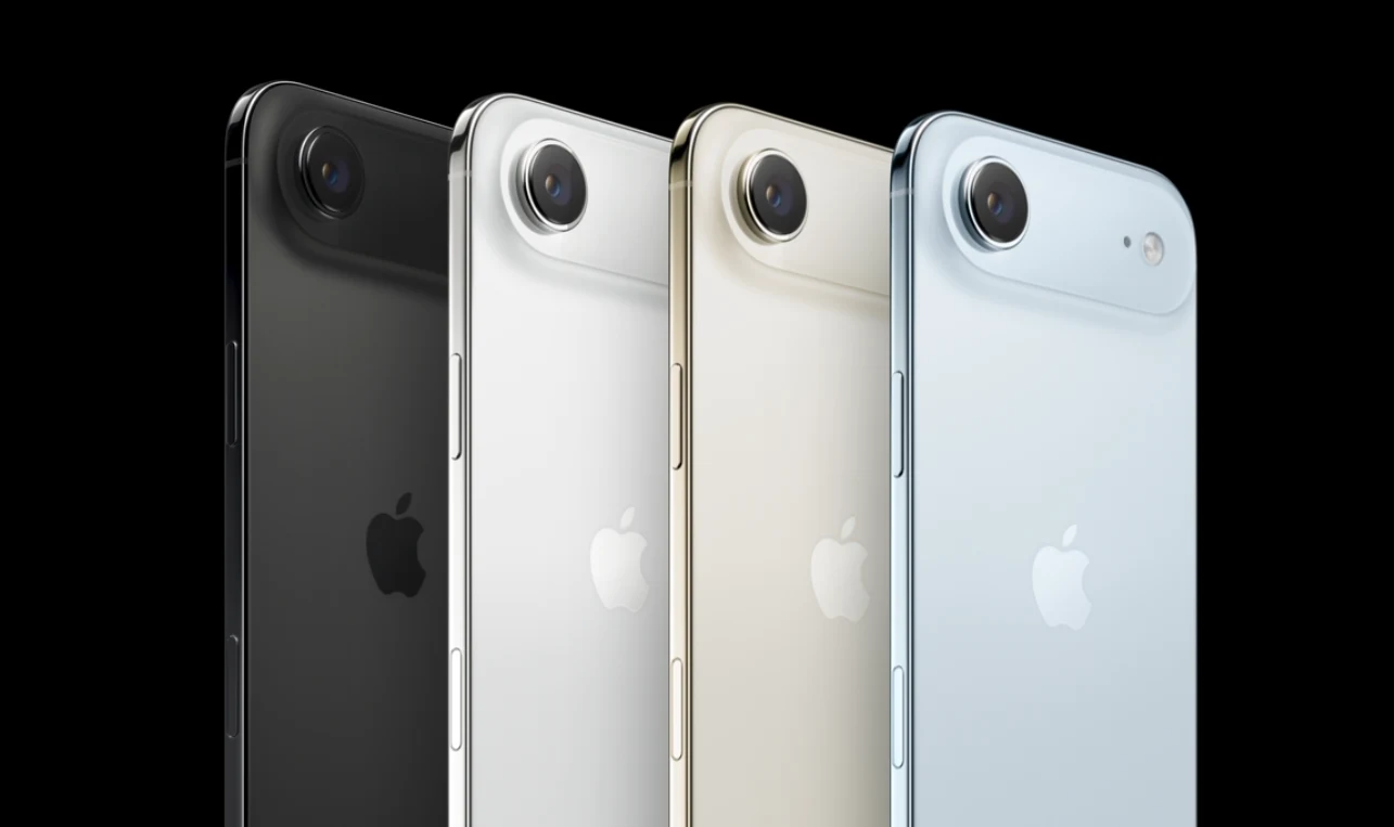 Cztery smartfony Apple ustawione w rzędzie, każdy w innym kolorze, na czarnym tle, z widocznym dużym obiektywem aparatu i logo firmy.