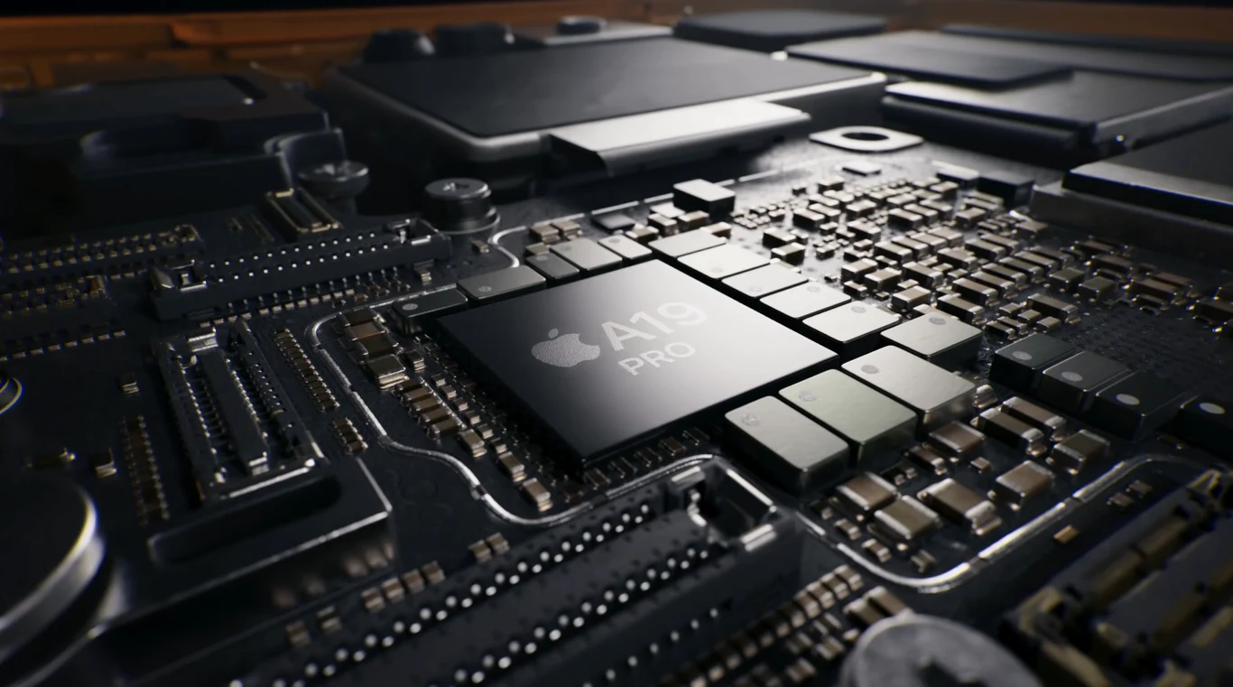 Układ scalony z centralnie umieszczonym chipem Apple A19 Pro otoczony szeregiem elementów elektronicznych na płytce drukowanej, widoczne drobne szczegóły mikroelektroniki i wyraźne oznaczenie modelu procesora.