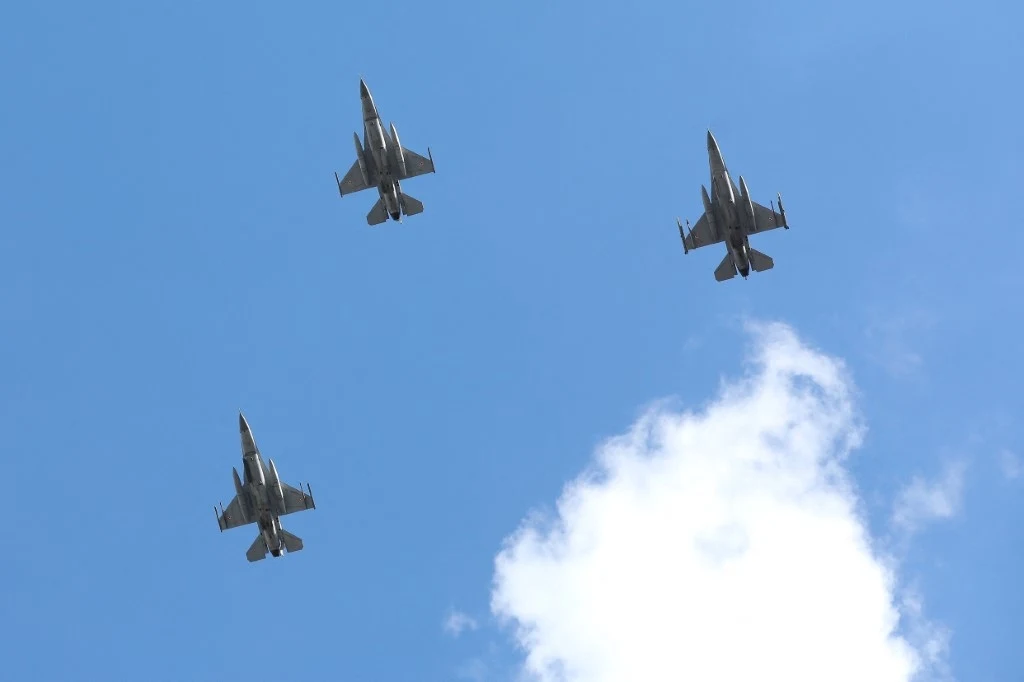 "Akt agresji". Zestrzelono rosyjskie drony, które wtargnęły do Polski Trzy wojskowe myśliwce lecą w formacji na niebie z niewielką ilością chmur, każdy skierowany przodem do obserwatora, na tle błękitnego nieba.