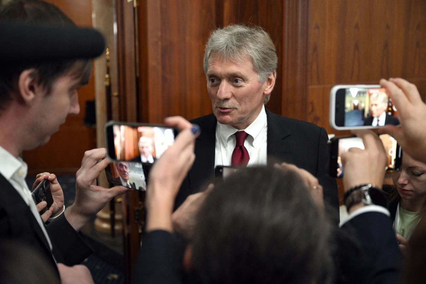 Dmitryj Pieskow nie chciał komentować sprawy naruszenia polskiej granicy przez rosyjskie drony Mężczyzna w garniturze i czerwonym krawacie udzielający wywiadu kilka osób otacza go i fotografuje lub nagrywa telefonami, tło stanowią drewniane panele ścienne.