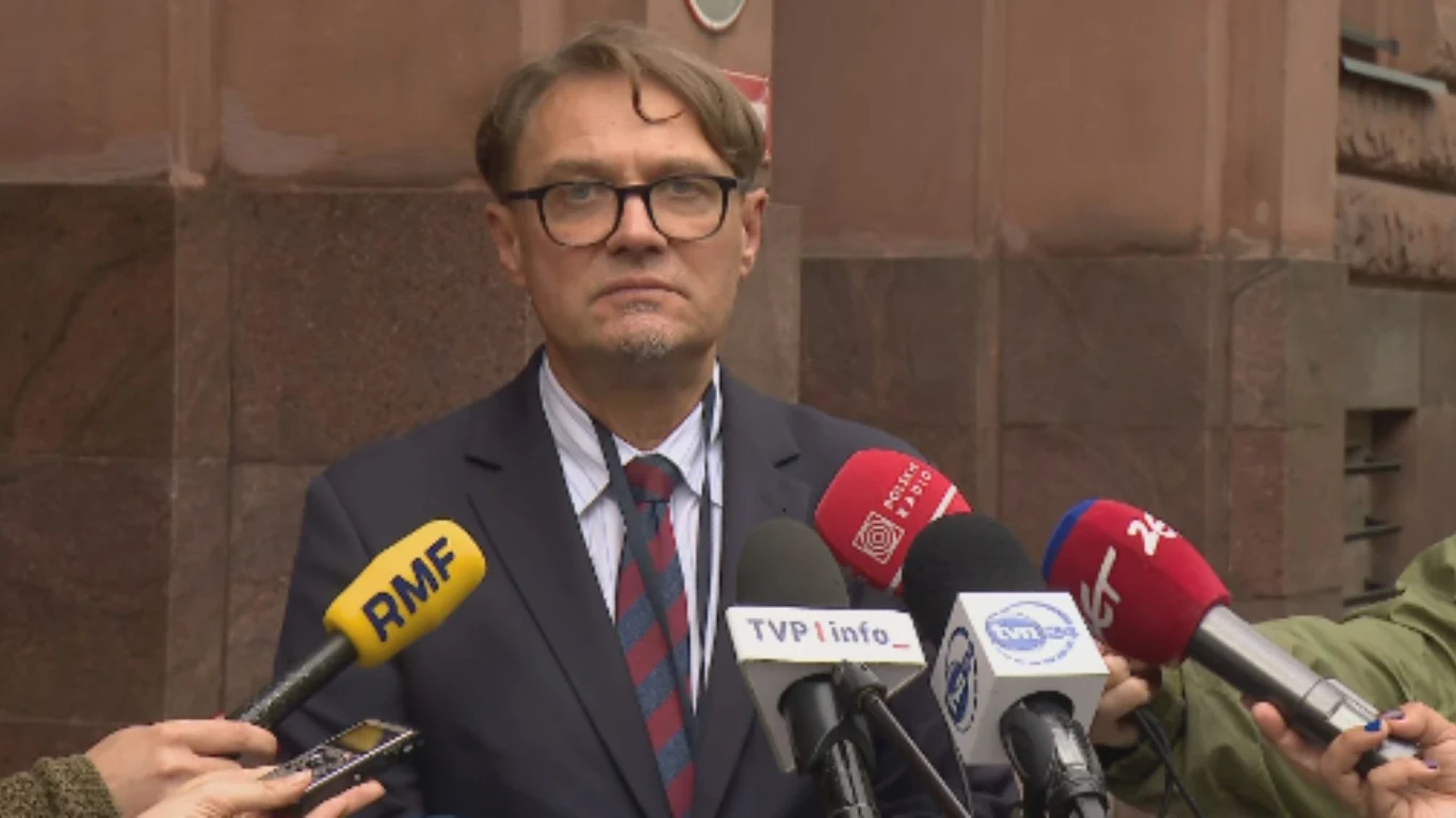 Rzecznik MSZ Paweł Wroński przekazał szczegóły dot. polskich więźniów uwolnionych z Białorusi Mężczyzna w okularach i garniturze udziela wypowiedzi do mikrofonów różnych stacji telewizyjnych przed budynkiem z cegły, otoczony przez dziennikarzy.