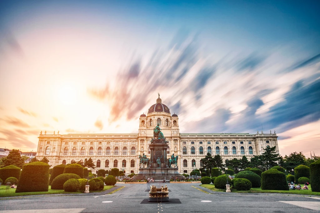 Europejskie miasta mogą mieć problem ze zmianą klimatu. Na zdjęciu: Wiedeń Monumentalny gmach muzeum z dużą kopułą pośrodku, otoczony starannie przyciętymi krzewami i alejkami, na pierwszym planie znajduje się pomnik konny ustawiony na wysokim cokole, nad całością rozpościera się kolorowe, dynamiczne niebo.