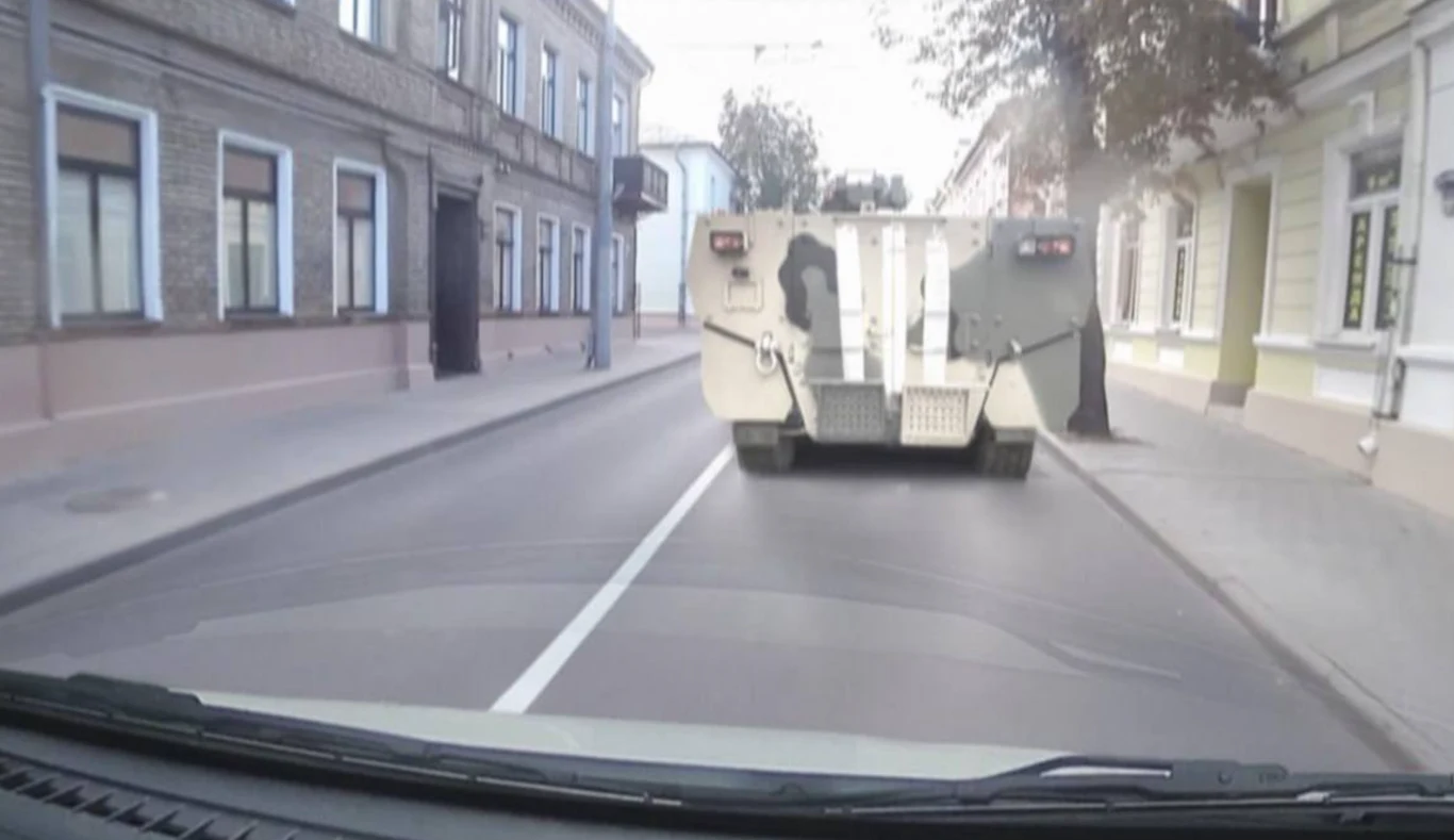 Transporter BTR-22 na ulicy w białoruskim Grodnie, niedaleko granicy z Polską Opancerzony pojazd wojskowy porusza się po pustej ulicy, między zabudowaniami mieszkalnymi w mieście, widziany z wnętrza innego pojazdu.