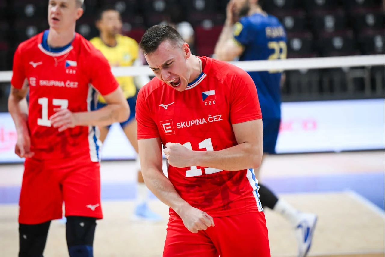 Lukas Vasina był liderem czeskiej drużyny na MŚ Zawodnik drużyny siatkarskiej ubrany w czerwony strój z numerem 11 wyraża intensywne emocje po udanej akcji, w tle inni gracze na boisku.