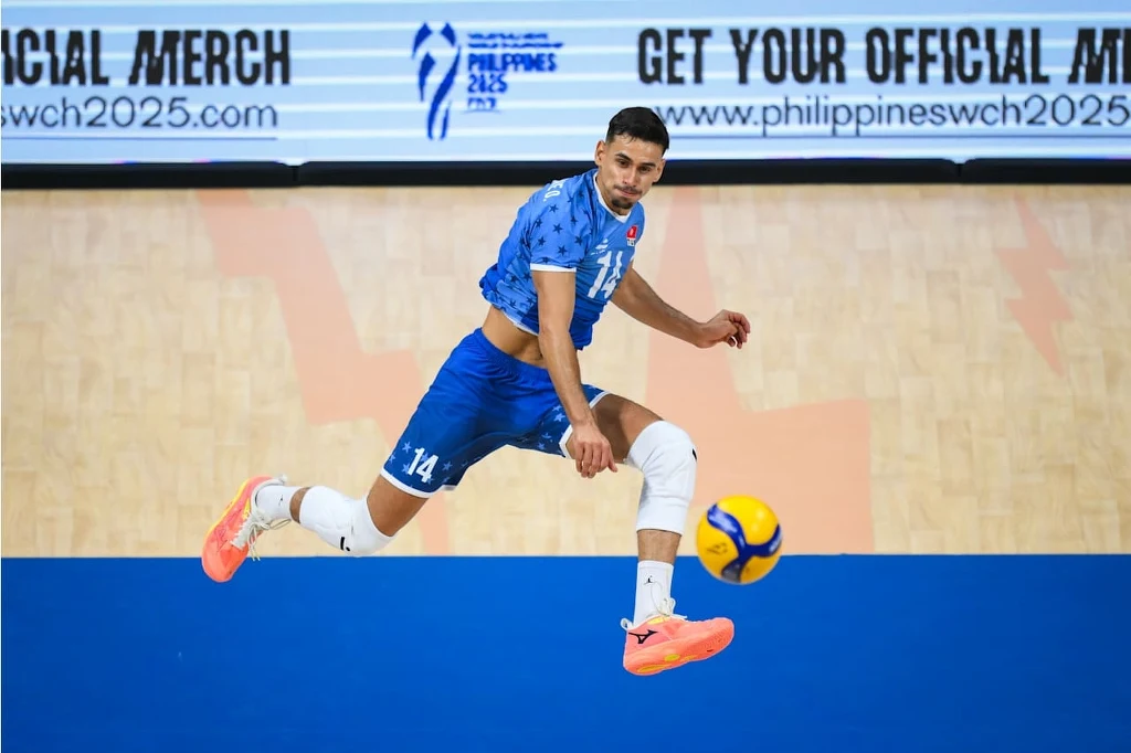 Tunezyjczycy sprawili Irańczykom sporo problemów Zawodnik siatkarski w niebieskim stroju wykonuje dynamiczny zwód na boisku, kontrolując piłkę w locie, w tle widoczna reklama turnieju sportowego.