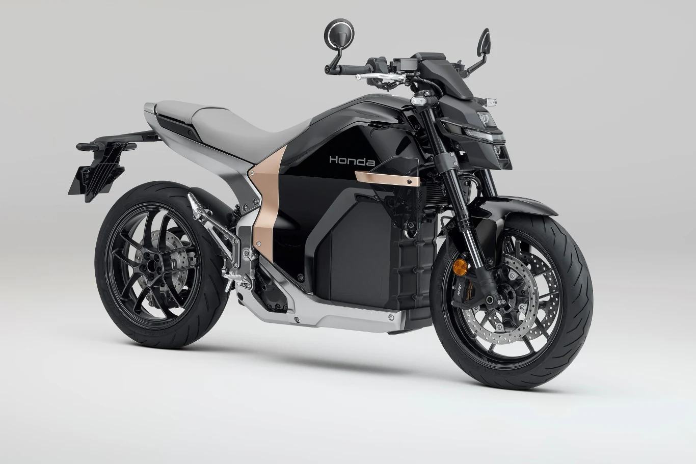 Honda WN7 - więcej szczegółów na temat elektrycznego modelu poznamy już niebawem. Nowoczesny motocykl elektryczny marki Honda w czarno-srebrnej kolorystyce o dynamicznej stylistyce z wyraźnie widocznym napędem elektrycznym oraz sportowym wykończeniem, stojący na szaro-białym tle.