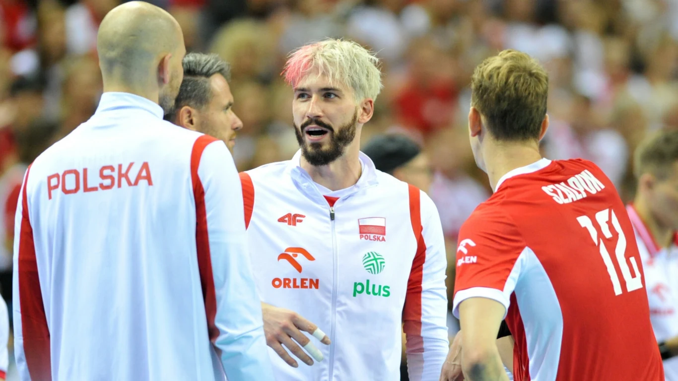 Tomasz Fornal Kilku zawodników polskiej reprezentacji siatkówki rozmawia ze sobą w trakcie meczu, wszyscy ubrani w biało-czerwone stroje z widocznymi logotypami sponsorów i napisami z nazwą kraju.