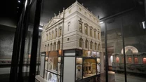 Model architektoniczny klasycznego budynku z odsłoniętymi, szczegółowo wykonanymi wnętrzami, ukazującymi różne pomieszczenia rozłożone na kilku poziomach.