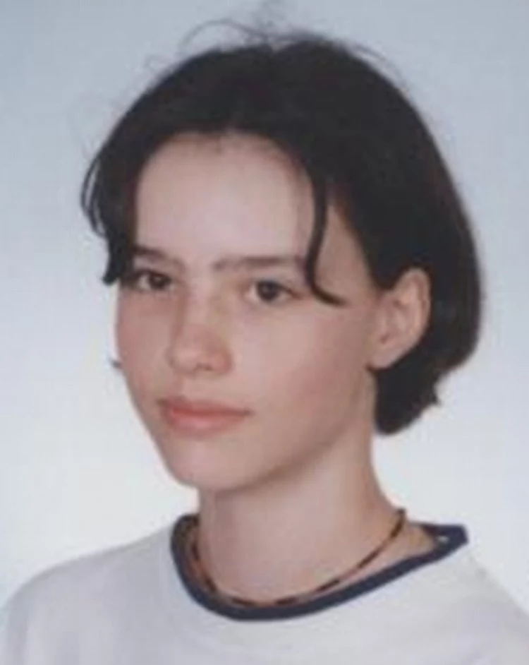 Olga Łuczyńska Młoda kobieta o krótkich, ciemnych włosach, ubrana w jasną bluzę i ciemny naszyjnik, patrząca spokojnie przed siebie na jasnym tle.