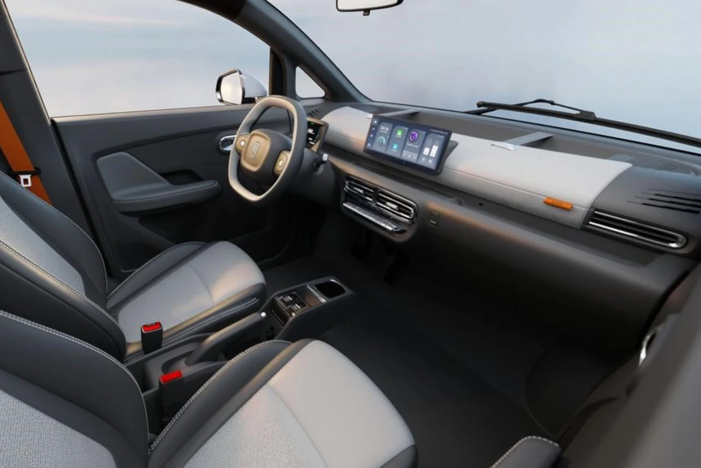 Nowoczesne wnętrze samochodu z szarymi fotelami, minimalistyczną deską rozdzielczą oraz dużym wyświetlaczem z panelem sterowania na konsoli centralnej, kierownicą oraz elementami wyposażenia o gładkich liniach.