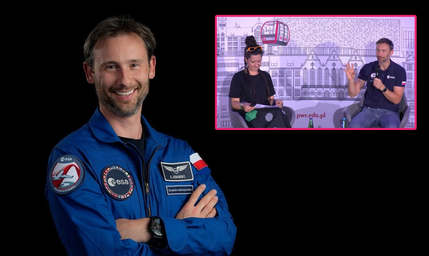 Sławosz Uznański-Wiśniewski był gościem Dolnośląskiego Festiwalu Nauki Mężczyzna w niebieskim kombinezonie astronauty z polską flagą na rękawie uśmiecha się z założonymi rękami, w prawym górnym rogu kadru widoczna jest scena rozmowy dwóch osób siedzących na tle z motywami kosmicznymi i budynków.