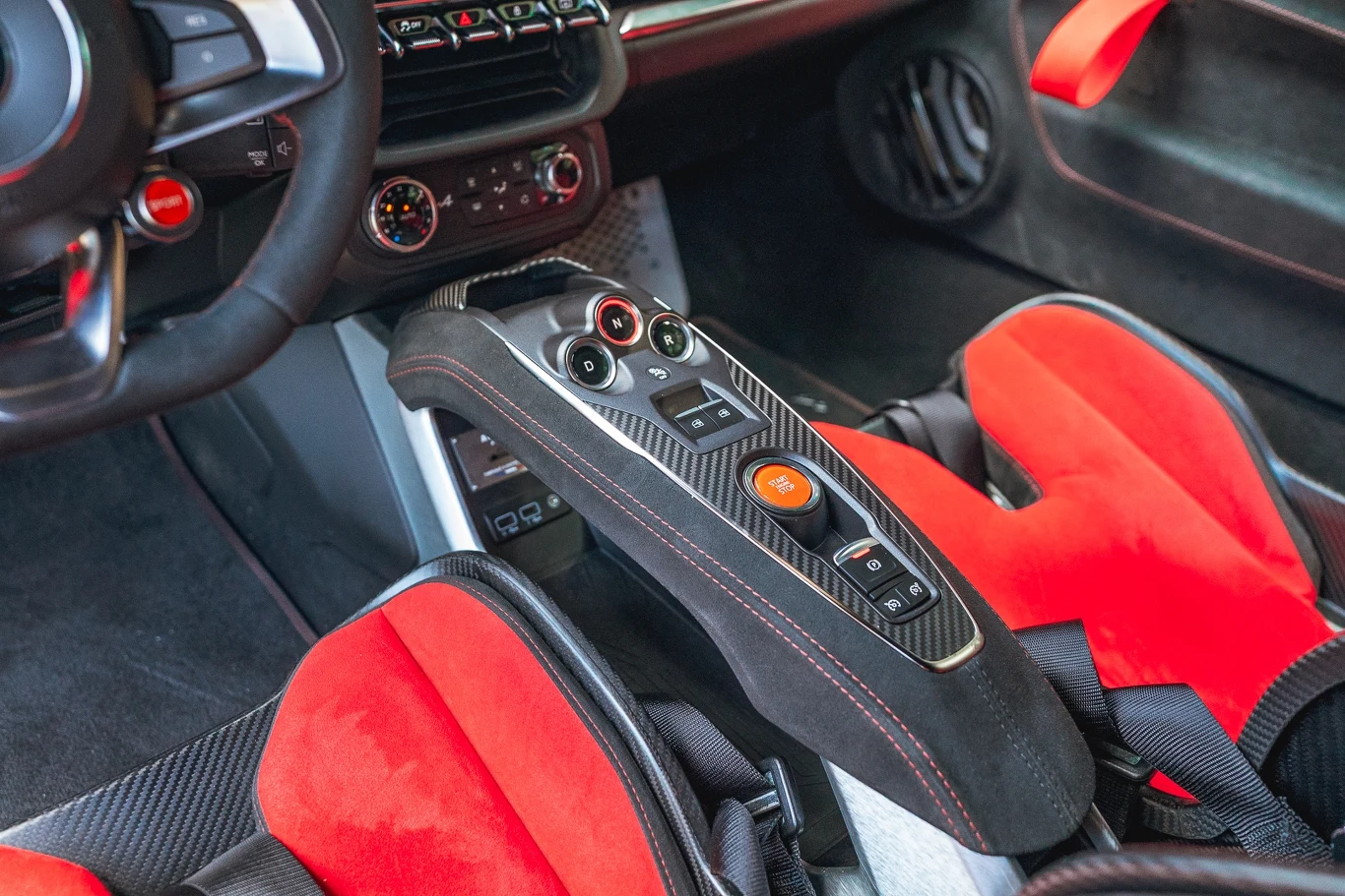 Lewitująca konsola w A110 nadal wygląda bardzo dobrze. Znalazły się na niej najważniejsze przełączniki (w tym wybierak dwusprzęgłowej skrzyni), a wykończono ją alcantarą, karbonem i szczotkowanym aluminium. Kokpit sportowego samochodu z wyraźnie widoczną konsolą środkową wykonaną z włókna węglowego, sportowymi fotelami pokrytymi czerwonym materiałem i detalami o wysokiej jakości wykończenia.