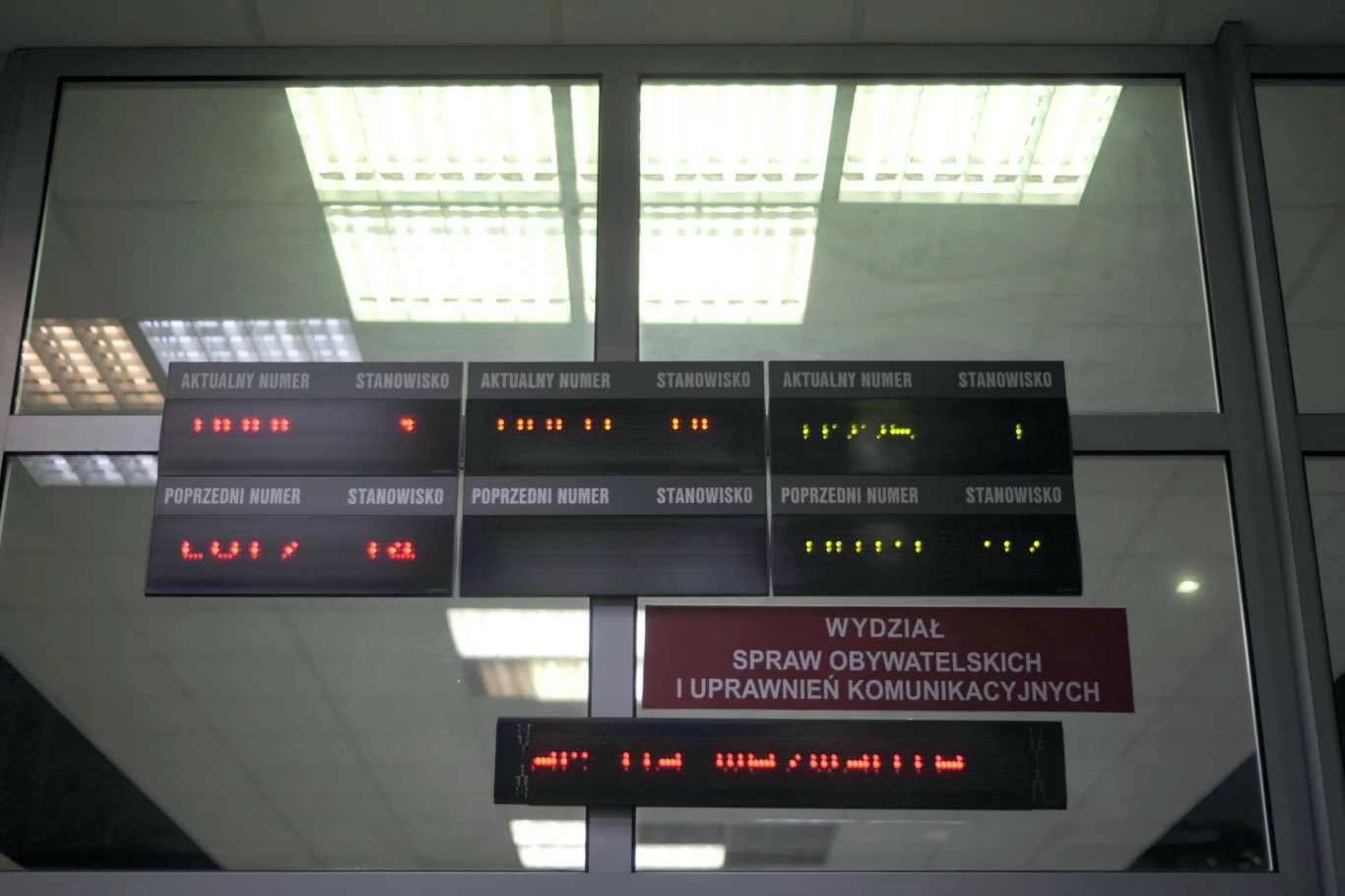 Mieszkańcy Poznania skarżą się na problemy z wymianą zagranicznego prawa jazdy Tablica z wyświetlaczami LED pokazującymi numery stanowisk i kolejek w urzędzie, w dolnej części widoczny szyld informujący o wydziale spraw obywatelskich i uprawnień komunikacyjnych.