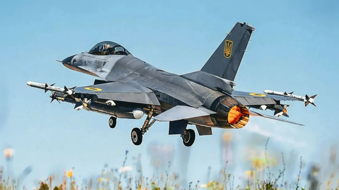 Ukraiński F-16 zestrzelił rosyjski dron z działka Vulcan Myśliwiec wojskowy w trakcie startu z widocznym płomieniem silnika odrzutowego, uzbrojony w pociski, oznaczony symbolem ukraińskim, unoszący się nad ziemią na tle czystego nieba.