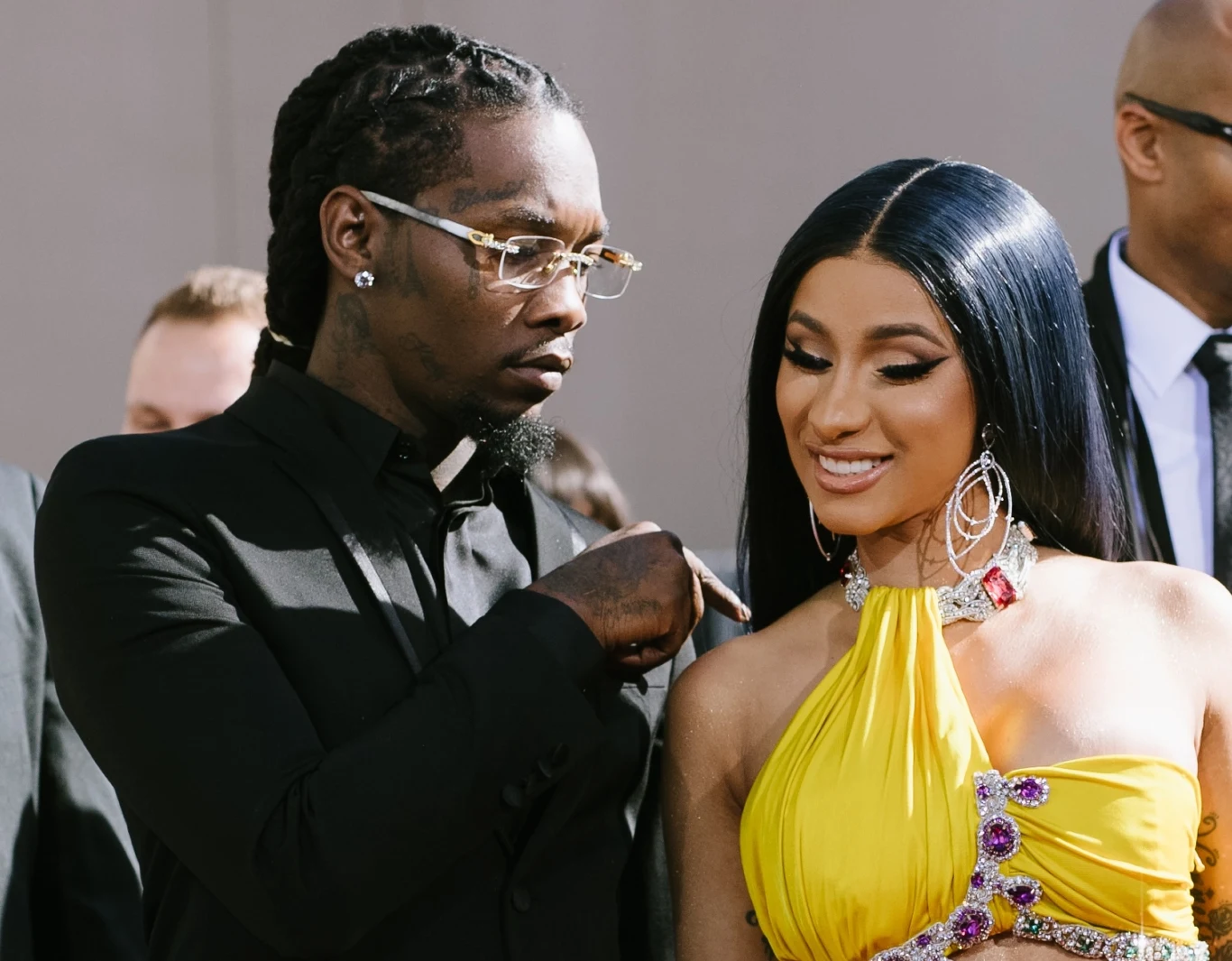 Offset i Cardi B rozstali się w 2024 roku Para uśmiechniętych osób w eleganckich strojach podczas oficjalnego wydarzenia, kobieta w efektownej żółtej sukni ozdobionej biżuterią, mężczyzna w czarnym garniturze z okularami przeciwsłonecznymi patrzy na towarzyszkę.
