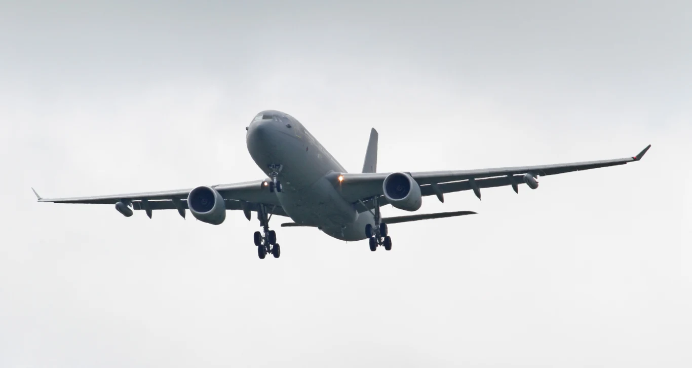 Brytyjczycy wysłali nad Polskę potężny tankowiec. To element Eastern Sentry Duży pasażerski samolot odrzutowy w locie na tle pochmurnego nieba z wysuniętym podwoziem.