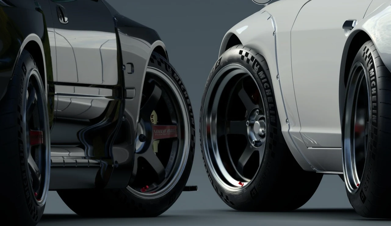 Gran Turismo 7 Gran Turismo 7 – zbliżenie na tylne koła i nadwozie dwóch sportowych aut z oponami Michelin.