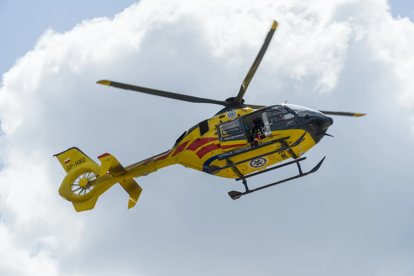 Dziewczynka wypadła z okna. Wypadek w Międzyrzeczu Żółty helikopter ratunkowy z widocznym oznaczeniem służby ratowniczej na tle nieba i białych chmur.