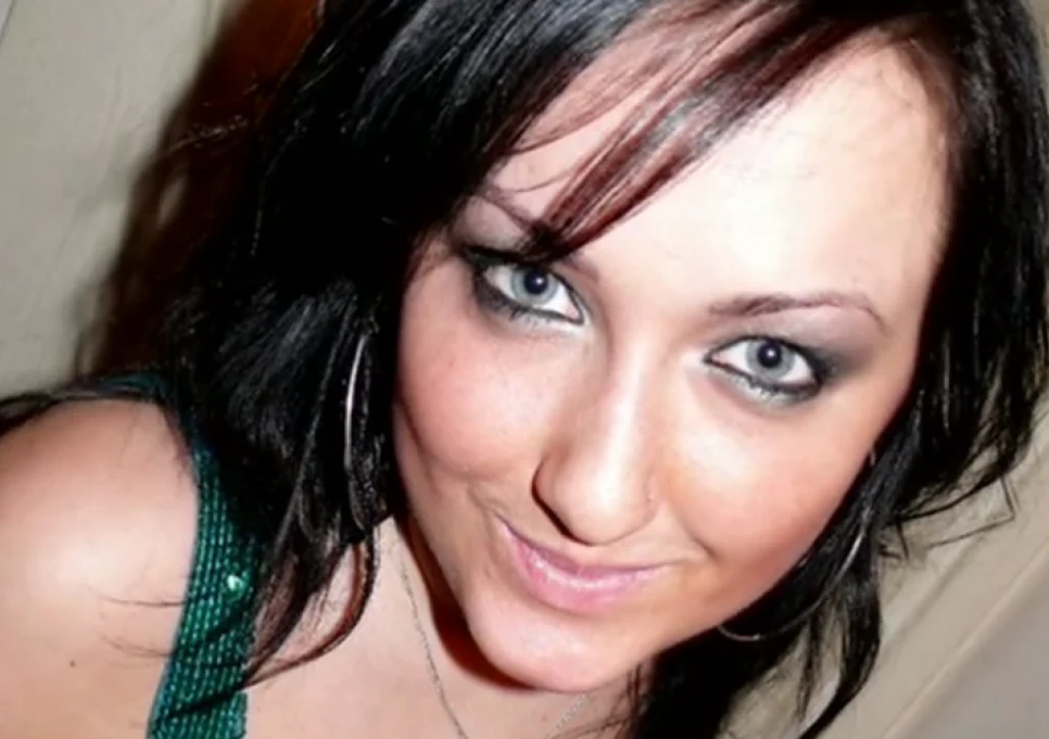 Uśmiechnięta młoda kobieta z ciemnymi włosami, patrząca prosto w obiektyw, ubrana w zielony top i z makijażem podkreślającym oczy.