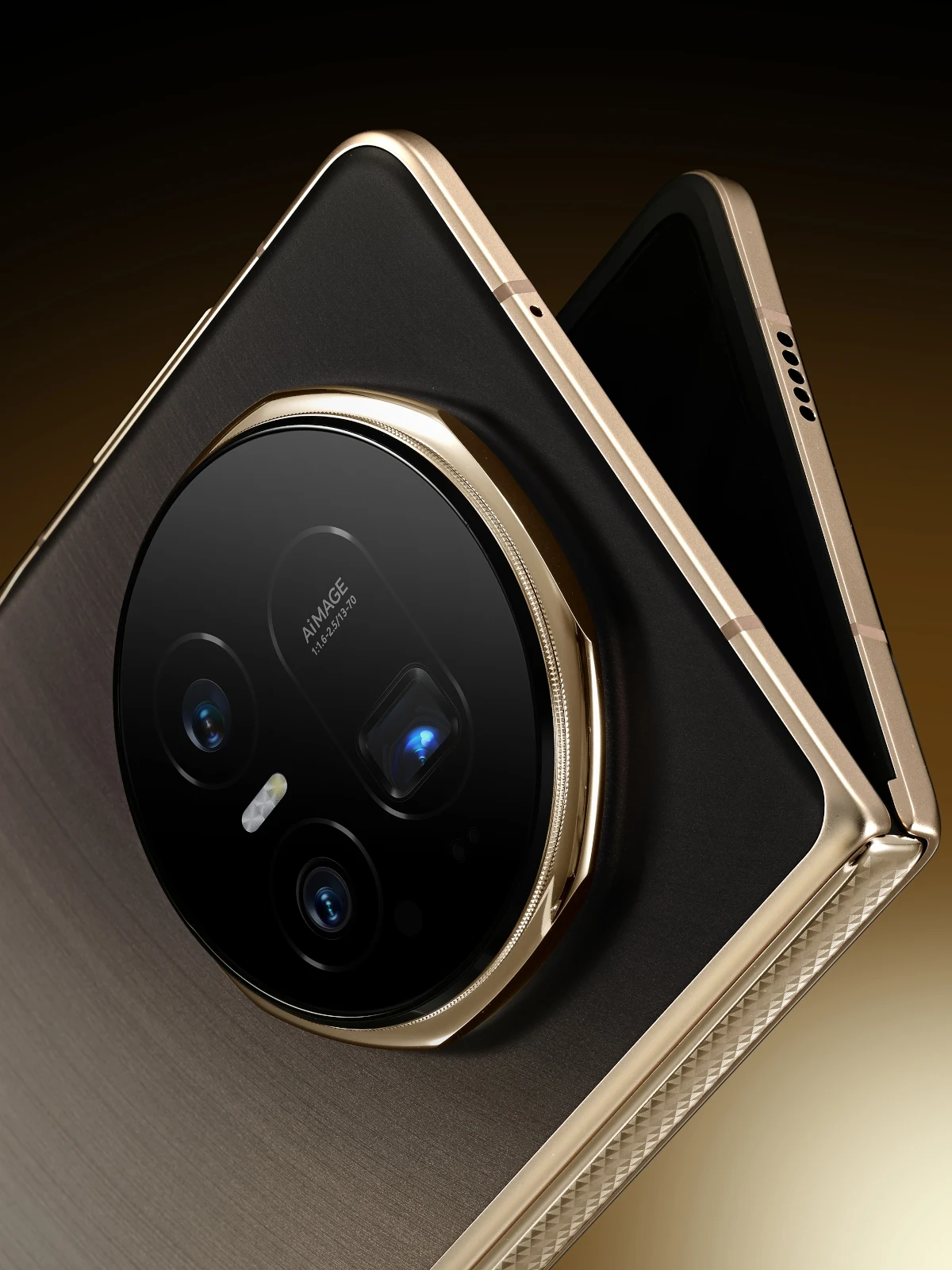 Nowoczesny składany smartfon w kolorze złotym z dużym modułem aparatu fotograficznego z kilkoma obiektywami i napisem 'AI IMAGE' na obiektywie, ujęcie skupia się na eleganckim wykończeniu i szczegółach technicznych telefonu.