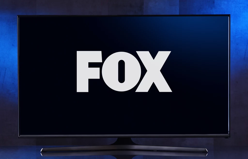 Czarny ekran telewizora z wyświetlonym dużym białym napisem FOX na niebieskim tle.