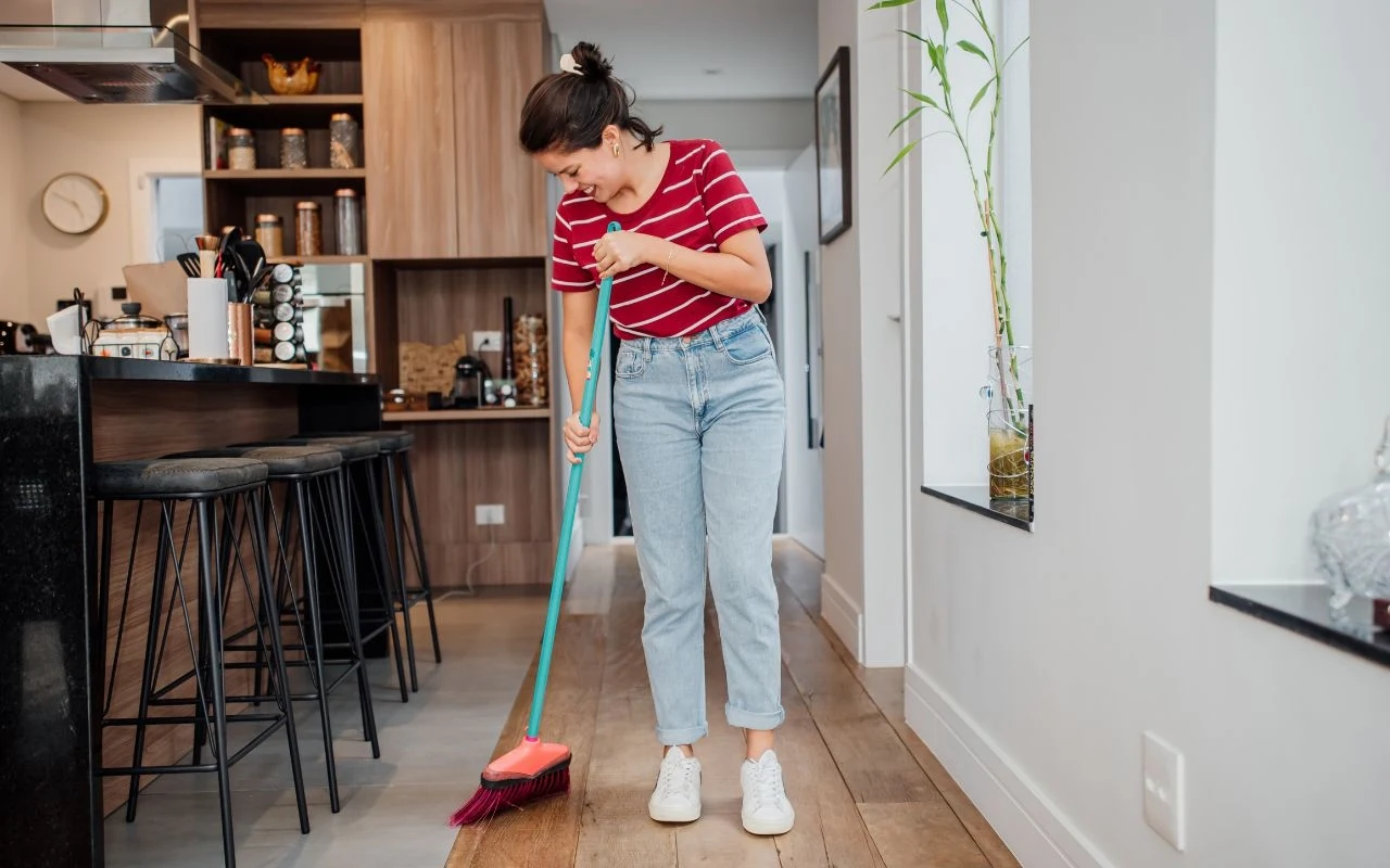 Nie rób tego w Wielki Piątek. Inaczej szczęście wyparuje z domu Sprzątanie domu w Wielki Piątek. Kobieta myjąca okna, symbol wielkanocnych porządków i dawnych przesądów