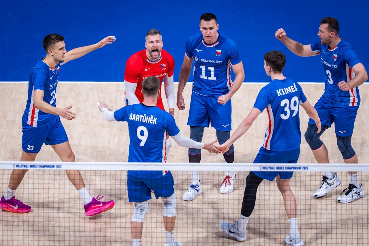 Siatkarze reprezentacji Polski Zespół siatkarzy w niebieskich strojach celebruje punkt na boisku, skupieni w kręgu zawodnicy wyrażają silne emocje, jeden z graczy wyróżnia się czerwonym strojem bramkarza.