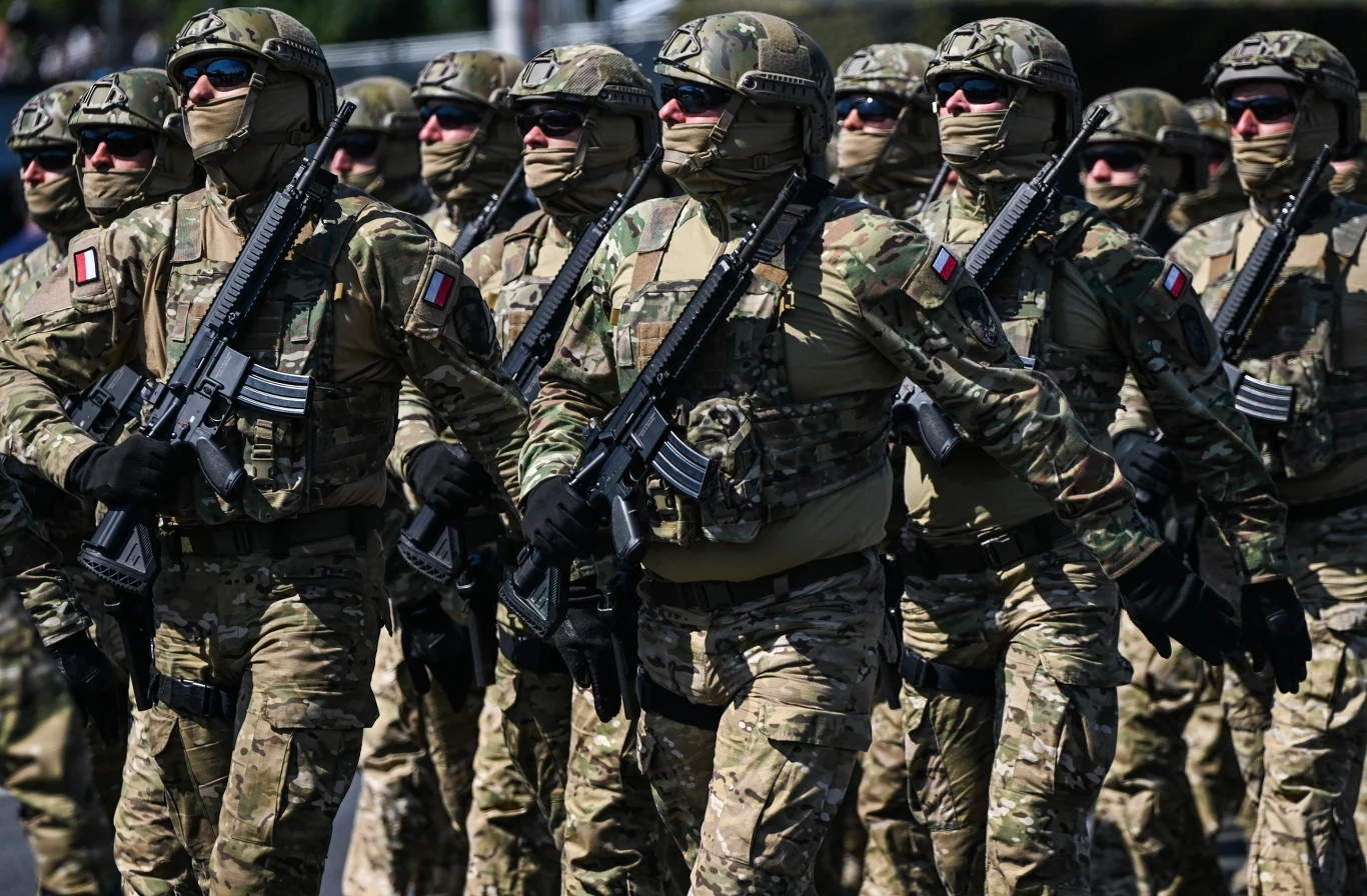 Polska wydaje ogromne pieniądze na zbrojenia. Oto największe kontrakty Grupa żołnierzy w pełnym umundurowaniu wojskowym, w kamuflażu i z bronią, maszeruje w zwartym szyku. Wszyscy mają na sobie maski zakrywające twarze oraz emblematy narodowe na ramionach.