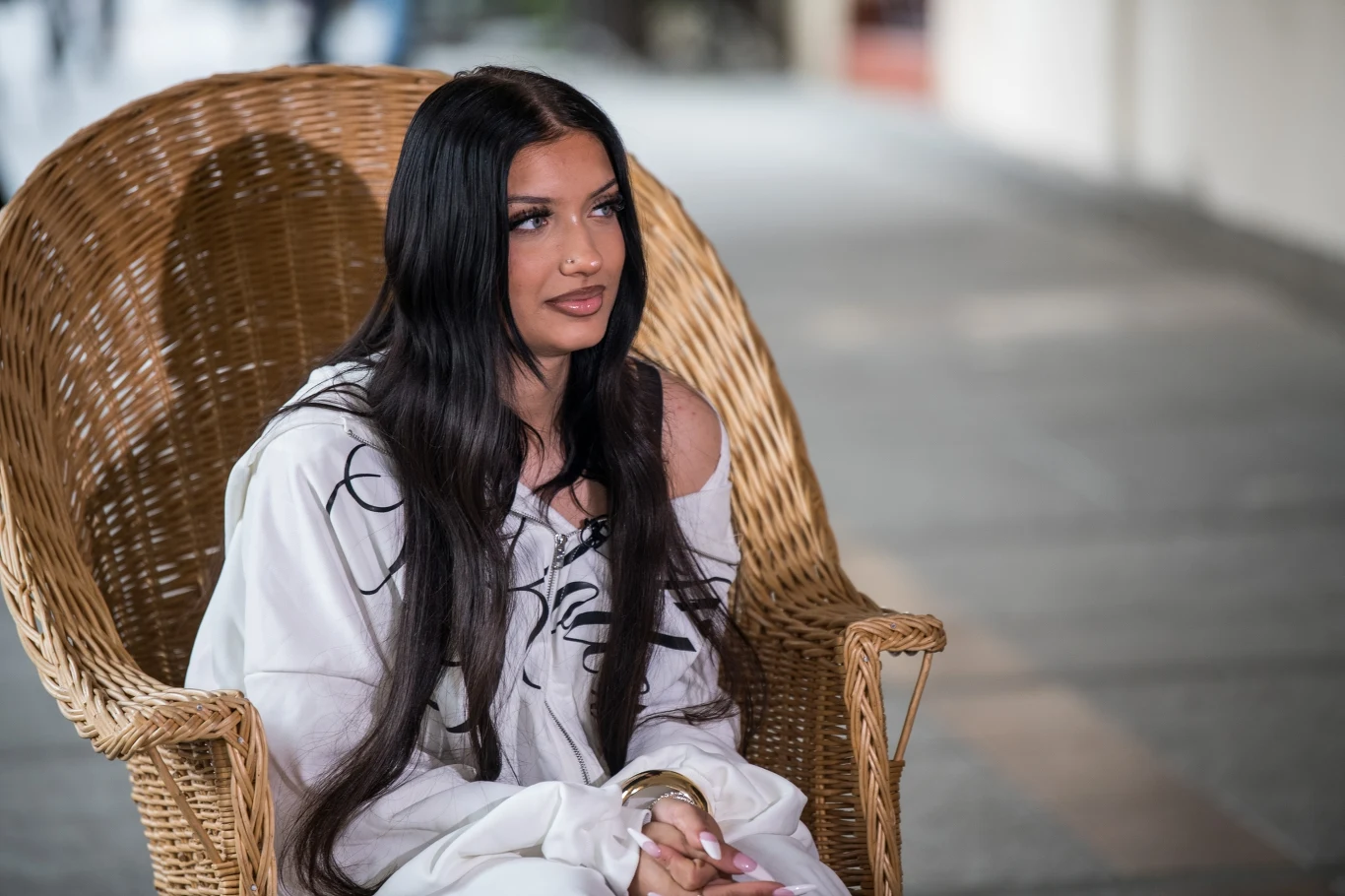 Viki Gabor prezentuje kolejny utwór Młoda kobieta z długimi, ciemnymi włosami siedzi na ażurowym fotelu z wikliny, ubrana w jasny strój z czarnymi wzorami, z zamyślonym wyrazem twarzy, w tle rozmyte otoczenie miasta.