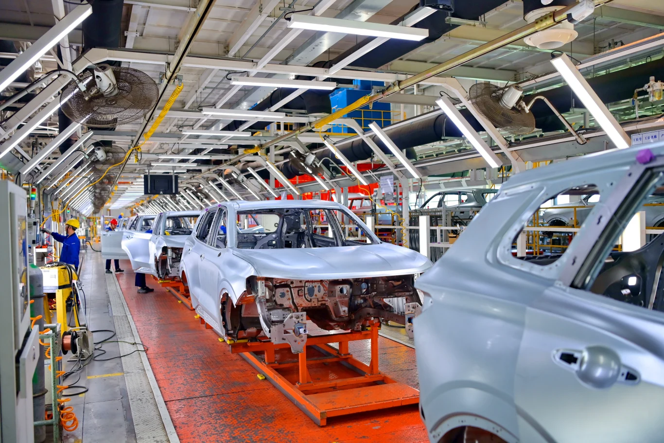 Kiekert AG, firma która pół wieku temu, jako pierwsza stworzyła centralny zamek, złożyła wniosek o upadłość. Dostarcza swoje produkty do ponad 100 marek na świecie Linia montażowa w fabryce samochodów z nieukończonymi nadwoziami aut ustawionymi jeden za drugim, oświetlone stanowiska pracy i pracownicy obsługujący maszyny produkcyjne