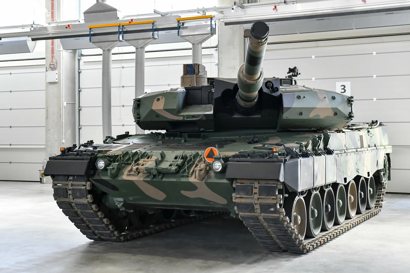 PGZ rozmawia ze stroną koreańską o zasadach polonizacji czołgów K2 Czołg bojowy w kamuflażu, ustawiony w przestronnej hali przemysłowej, skierowany lufą do przodu, z widocznymi detalami pancerza i gąsienic.