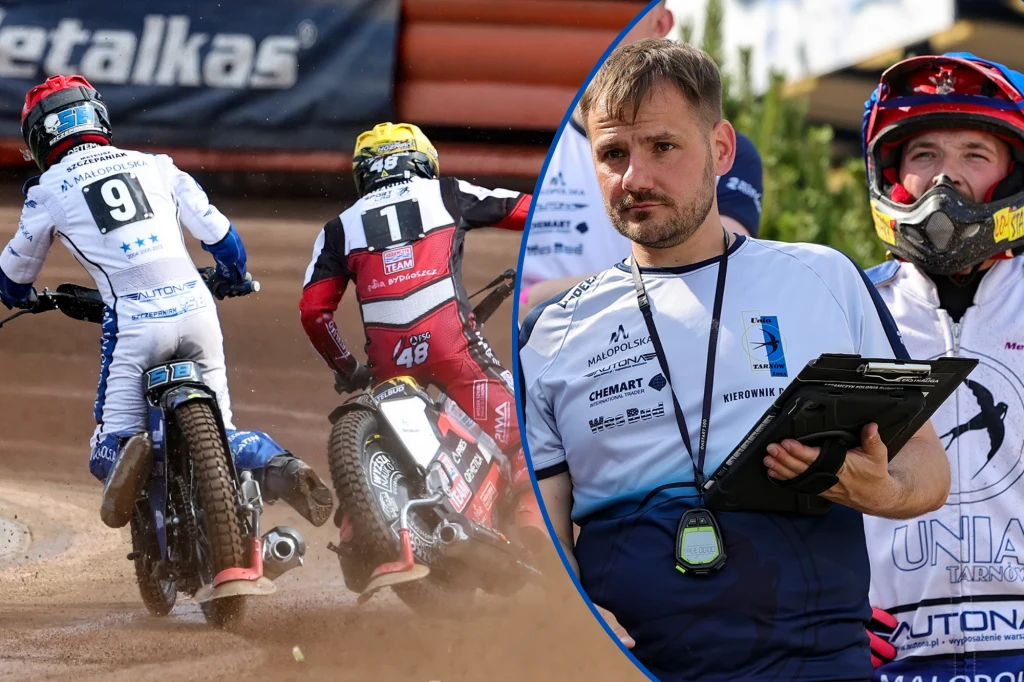 Dwóch żużlowców jadących na motocyklach po torze oraz trener lub sędzia z tabletem w ręku, ubrany w koszulkę drużynową, w tle drugi członek ekipy w kasku.