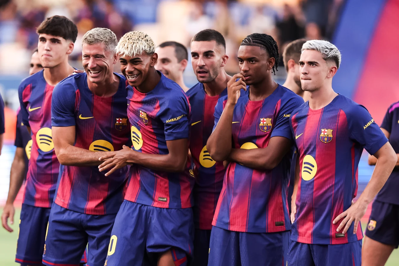 Lamine Yamal znów może występować na murawie w barwach FC Barcelona Grupa piłkarzy FC Barcelony ubranych w oficjalne stroje zespołu, stojących obok siebie na murawie boiska, wszyscy uśmiechnięci i zrelaksowani podczas wspólnego zdjęcia.