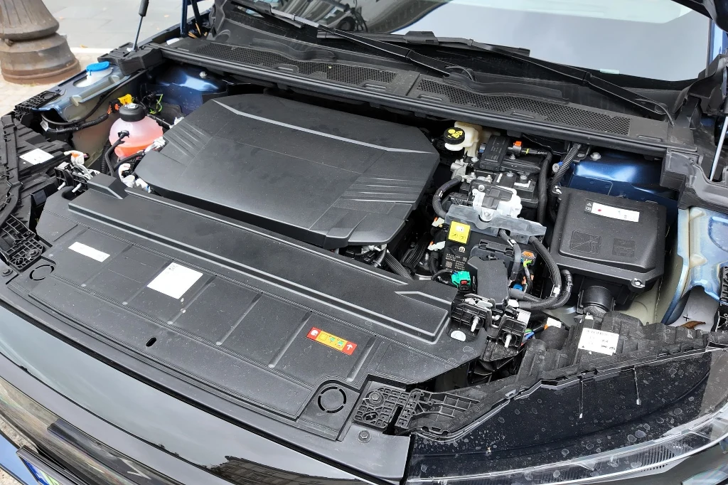 Otwarta maska samochodu z widocznym silnikiem, zbiornikami płynów eksploatacyjnych oraz innymi elementami mechaniki pojazdu, całość w dobrze utrzymanym stanie technicznym.