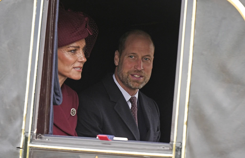 Prawdziwe oblicze związku Kate i Williama jest nieco inne, niż medialny obraz Dwoje elegancko ubranych ludzi siedzi w powozie, kobieta w bordowym stroju i kapeluszu oraz mężczyzna w garniturze z krawatem spoglądają przez otwarte okno powozu.