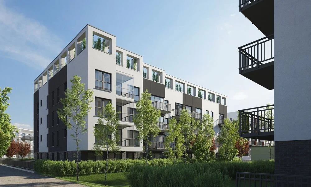 Murapol poszerza ofertę o blisko 300 mieszkań Nowoczesny budynek wielorodzinny z dużymi oknami, balkonami i zielenią wokół, otoczony młodymi drzewami oraz zadbanym trawnikiem, w tle inne budynki mieszkalne.
