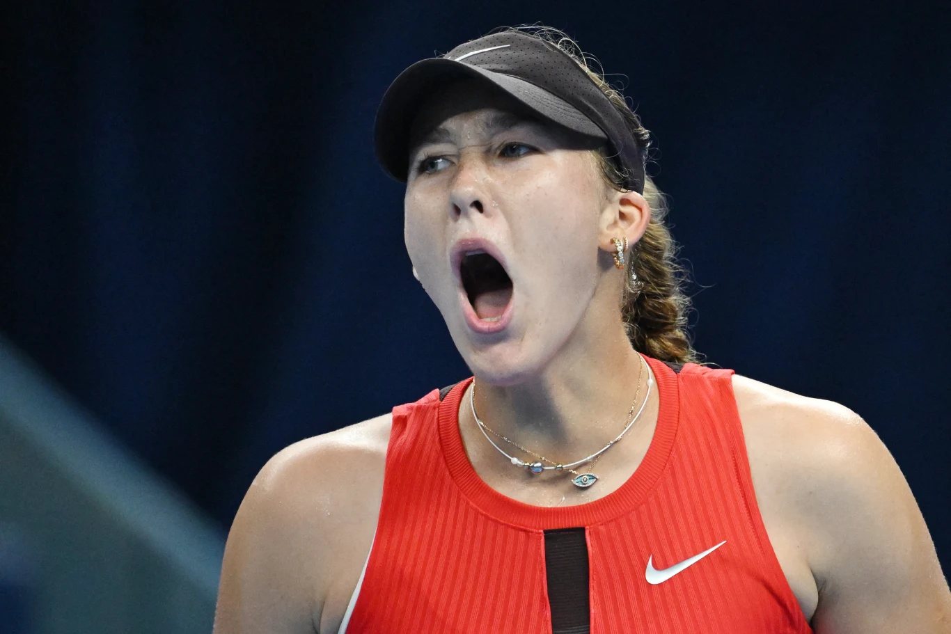 Mirra Andriejewa debiutuje w WTA Finals Zawodniczka tenisa ubrana w czerwoną koszulkę i czarną czapkę z daszkiem, wyraża silne emocje przez otwarte usta jakby krzycząc podczas meczu.