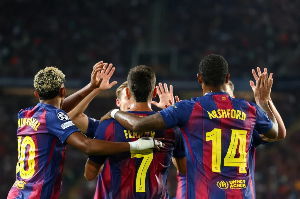 FC Barcelona celebrująca bramkę w meczu z PSG (1.10.2025) Grupa piłkarzy w strojach klubowych świętuje zdobycie bramki poprzez podniesione ręce oraz wzajemne przytulania, widoczne są numery na koszulkach i nazwiska zawodników.