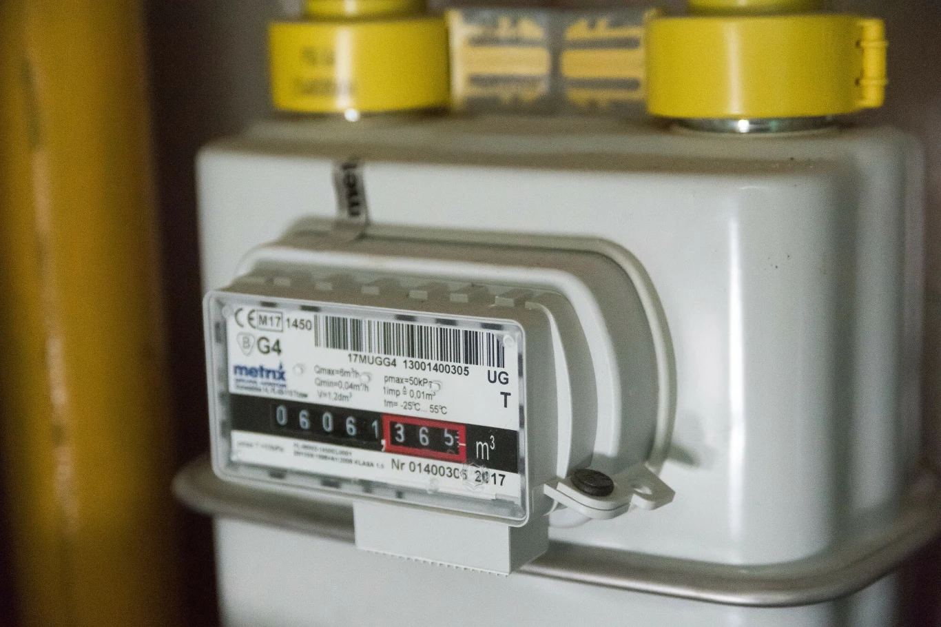 Zarzuty UOKiK dla dostawców gazomierzy Licznik gazu z wyraźnie widocznymi cyframi pomiaru zużycia paliwa, metalowa obudowa z dwoma żółtymi zaworami i etykietami technicznymi.