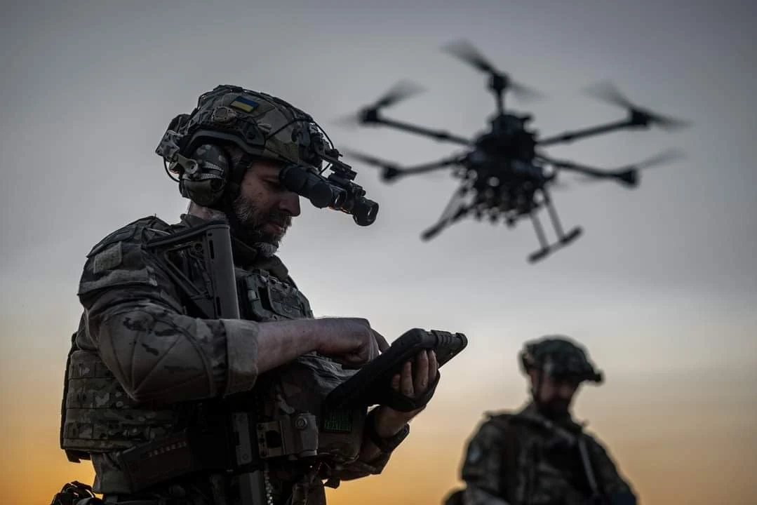 Rzecznik Kremla stwierdził, że USA przekazuje dane wywiadowcze Ukrainie Dwóch żołnierzy w mundurach taktycznych z noktowizorami obsługuje tablet, na którym najprawdopodobniej kontrolują wojskowego drona latającego nad nimi na tle zachodzącego słońca.
