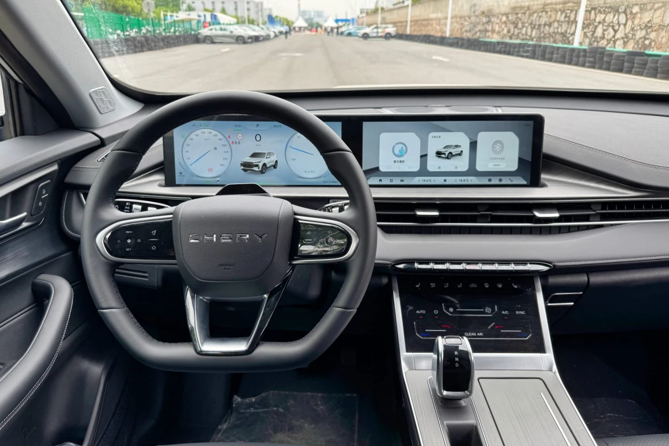 Nowoczesne wnętrze samochodu z cyfrowym kokpitem, dużymi wyświetlaczami na desce rozdzielczej, kierownicą wielofunkcyjną oraz panelem sterowania na konsoli centralnej.