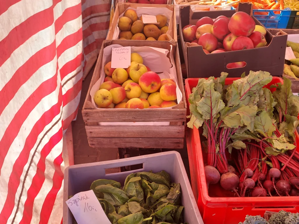 Sadownicy narzekają na końcówkę sezonu. "Nie ma po co jechać na rynek" Drewniane i plastikowe skrzynki wypełnione jabłkami, burakami oraz świeżym szpinakiem ustawione na targowym stoisku pod biało-czerwonym, paskowanym namiotem.