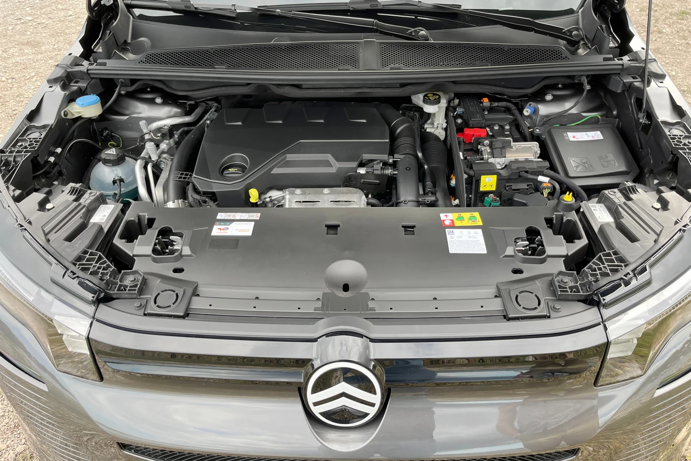 Wersja plug-in łączy benzynowy silnik 1.6 o mocy 150 KM z jednostką elektryczną o mocy 125 KM. Komora silnika samochodu Citroën z otwartą maską, z widocznymi podzespołami silnika oraz elementami technicznymi, takimi jak akumulator i płyny eksploatacyjne.